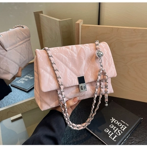 Detail of pink quilted shoulder bag with silver chain strap and metallic ball charm