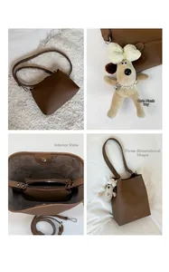 Detail view of brown lychee grain leather bucket bag with plush dog charm and inner pouch