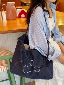 Deep blue denim tote bag with large white 'hoo' letter embroidery and contrast stitching