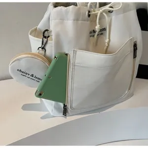 Detail view of canvas bucket bag with functional side zipper pocket for phone storage