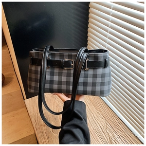 Detail of grey plaid tote bag featuring leather straps and silver metal buckles