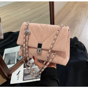 Detail of pink quilted leather crossbody bag with V-shaped stitching and silver clasp