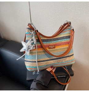 Détail d'un sac de plage tissé à rayures colorées avec bandoulière en cuir et étoile