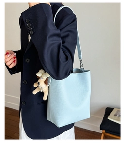 Detail of light blue lychee pattern bucket bag with a cute puppy plush charm