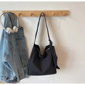 Detail of black and white checkered canvas tote bag with matching small zip pouch
