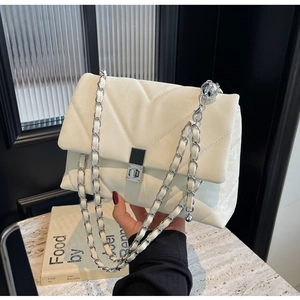 Detail of V-quilted faux leather bag with silver twist lock and metal chain strap
