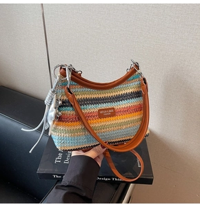 Détail d'un sac à bandoulière en paille tressée colorée avec sangle en cuir et étoile