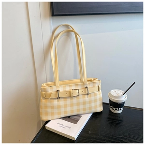 Detail of yellow checkered shoulder bag with silver buckle and leather strap decoration