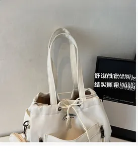 Close-up of white canvas tote bag with drawstring closure and matching round coin purse detail