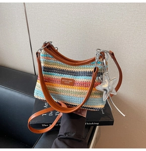 Détail d'un sac en paille tissé coloré avec des lanières en cuir et un pendentif étoile
