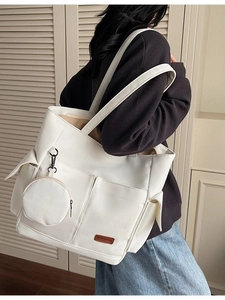Minimalist white canvas tote bag with multi-pocket design and small round coin purse