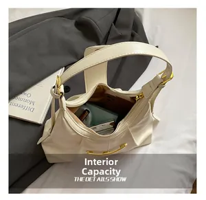 Capacité interne du sac sous l'aisselle plissé crème montrant les objets du quotidien