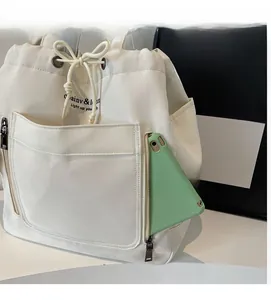 Detail view of canvas drawstring bag featuring a side zipper pocket for smartphone storage