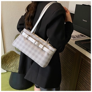 Detail of grey gingham tote bag featuring silver metal buckles and leather strap accents