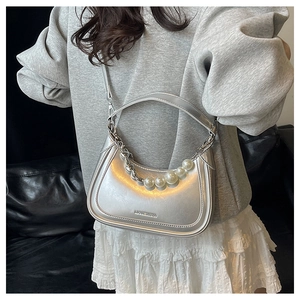 Détail du sac demi-lune argenté avec chaîne de perles et finition métallique brillante