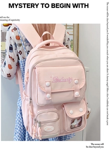 Vue détaillée du sac à dos en toile rose clair avec plusieurs poches et broderie Doherty