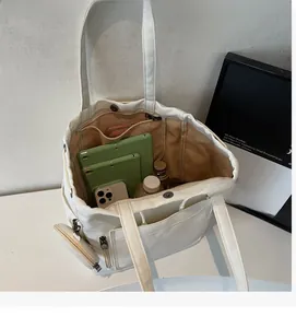 Detailed interior of a white canvas tote bag showing large capacity and side pockets