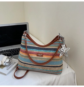 Détail du sac de plage tressé multicolore avec poignées en cuir marron et breloque étoile