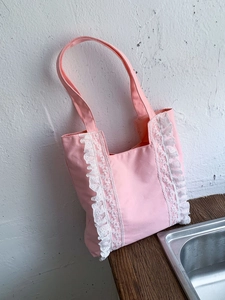 Pink canvas tote bag with white lace ruffles and long shoulder straps for women
