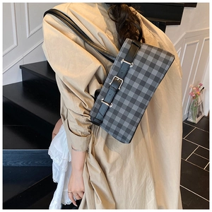 Shoulder bag detail showing black and gray checkered fabric with silver buckle strap