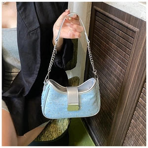 Detail of light blue denim hobo bag with sparkling rhinestones and silver chain strap