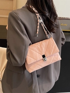Pink quilted chain square bag with pleated texture and silver twist lock on shoulder