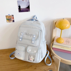 Détail d'un sac à dos bleu-gris clair avec plusieurs poches et fenêtre transparente étoile