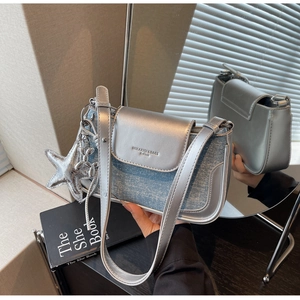 Detail of silver metallic leather and blue denim crossbody bag with star and balloon dog charm