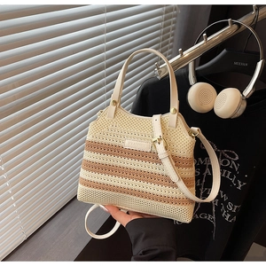 Detail of hand-woven bucket bag with beige and brown stripes and a leather logo