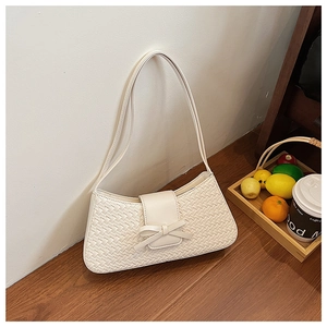 Close-up of white woven PU shoulder bag with bow detail and rectangular baguette shape