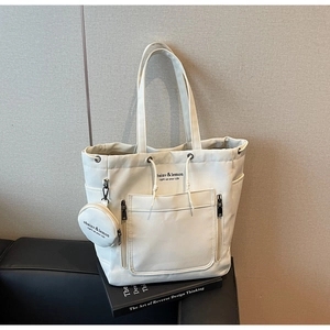 Detail of off-white canvas tote bag with drawstring closure and matching coin purse pouch