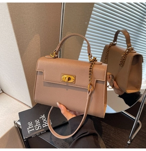 Detailed view of mocha brown Kelly bag with gold twist lock and textured leather