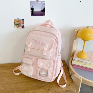 Détail du sac à dos scolaire rose clair avec poches multiples et décoration d'étoile