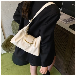Détail du sac à bandoulière plissé crème en similicuir brillant avec boucle dorée chic