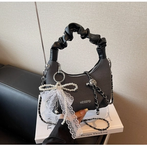 Detailed view of the dark grey textured dumpling bag with leather handle and pearl charm