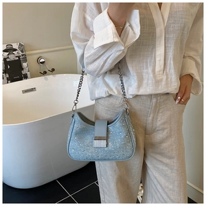 Detail of light blue denim rhinestone bag with silver chain strap and metal lock