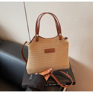 Detail showing the leather handle and logo tag on a woven knit bucket bag for women