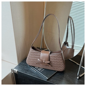 Detailed shot of dark brown woven leather shoulder bag with decorative bow accent