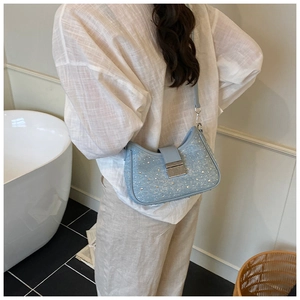 Close-up of sparkling denim crescent bag with shiny sequins and silver metal buckle