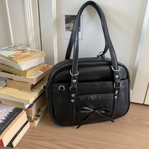 Detail of JK style bag featuring heart metal charm, bow knot, and wavy scalloped edge trim