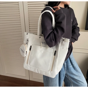 Detail of white large capacity tote bag with dual front zippers and small round coin purse