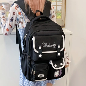 Détail d'un sac à dos noir style campus avec liserés blancs et broderie d'étoiles