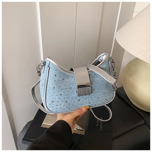 Detail of blue denim moon bag with sparkling rhinestones and silver metal chain accessory