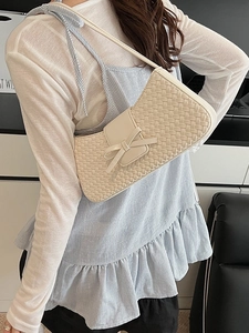 Minimalist cream woven shoulder bag featuring a stylish bow and chic textured finish