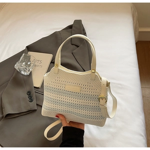 Detail of hand-woven bucket bag with blue gradient stripes and golden hardware
