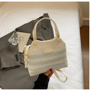 Detail of knit bucket bag with beige mesh texture, blue stripes and leather strap