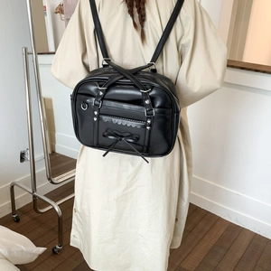 Close-up of black JK style leather tote bag with heart bow and silver studs detail