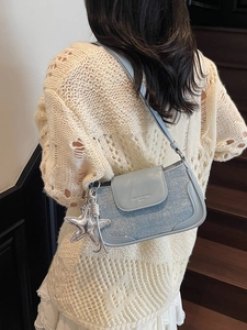 Light blue sequin shoulder bag with starfish pendant worn by model on stairs