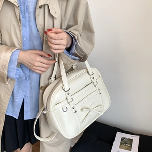Close-up of cream JK style handbag featuring heart studs and a cute bow decoration