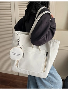 Off-white large canvas tote bag with drawstring detail and round coin purse on shoulder